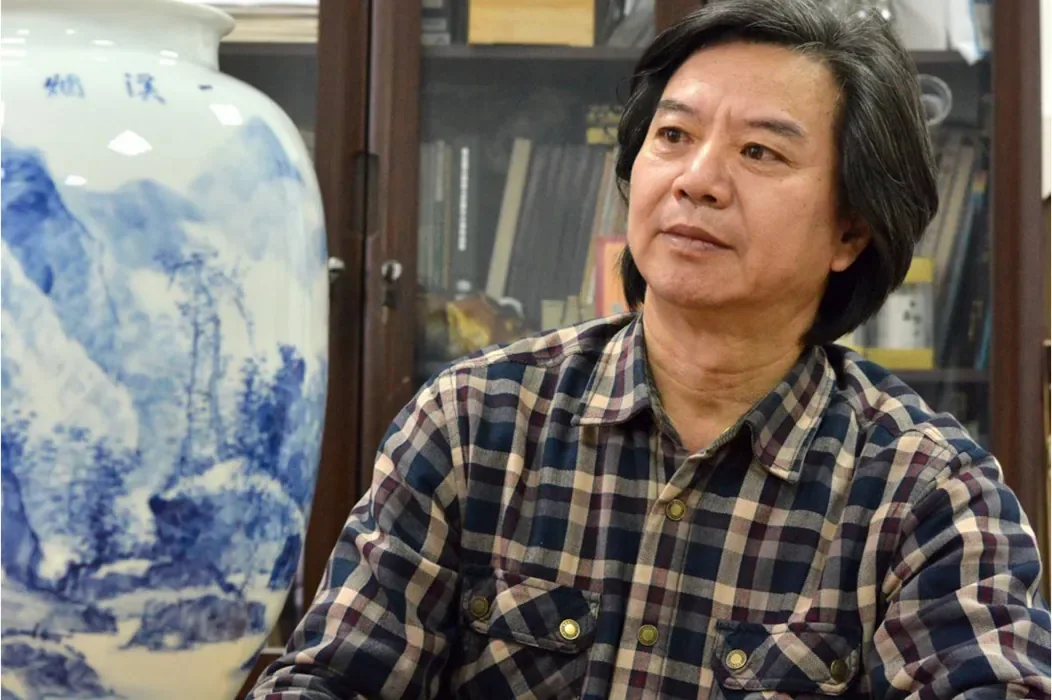 Ceramic artist Yang Shuhua beside a blue-and-white landscape vase
