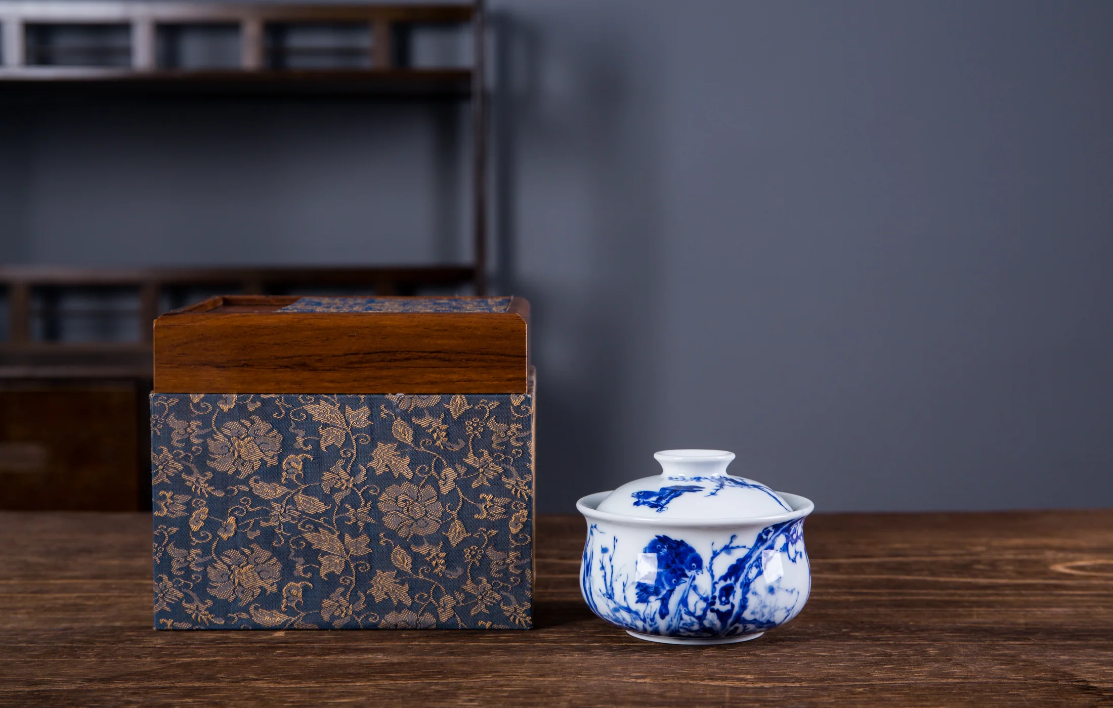 Blue-and-white covered tea vessel shown with its presentation box